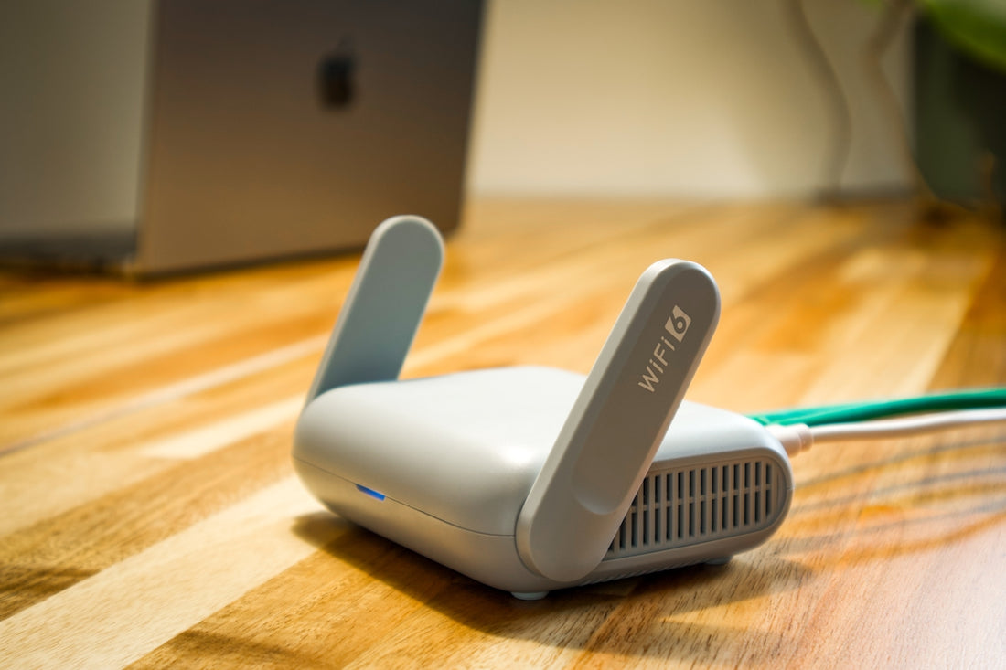 A wireless router sits on a wooden table.