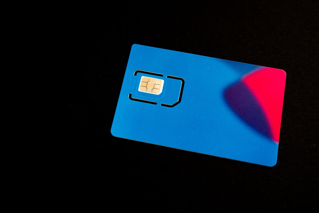 A blue sim card sits on a dark surface.